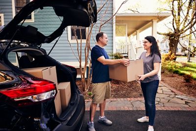 Couple moving boxes into new home